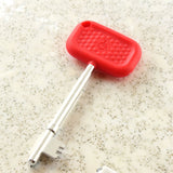 Red Lokko disabled toilet key for NKS/Radar doors on a speckled surface.